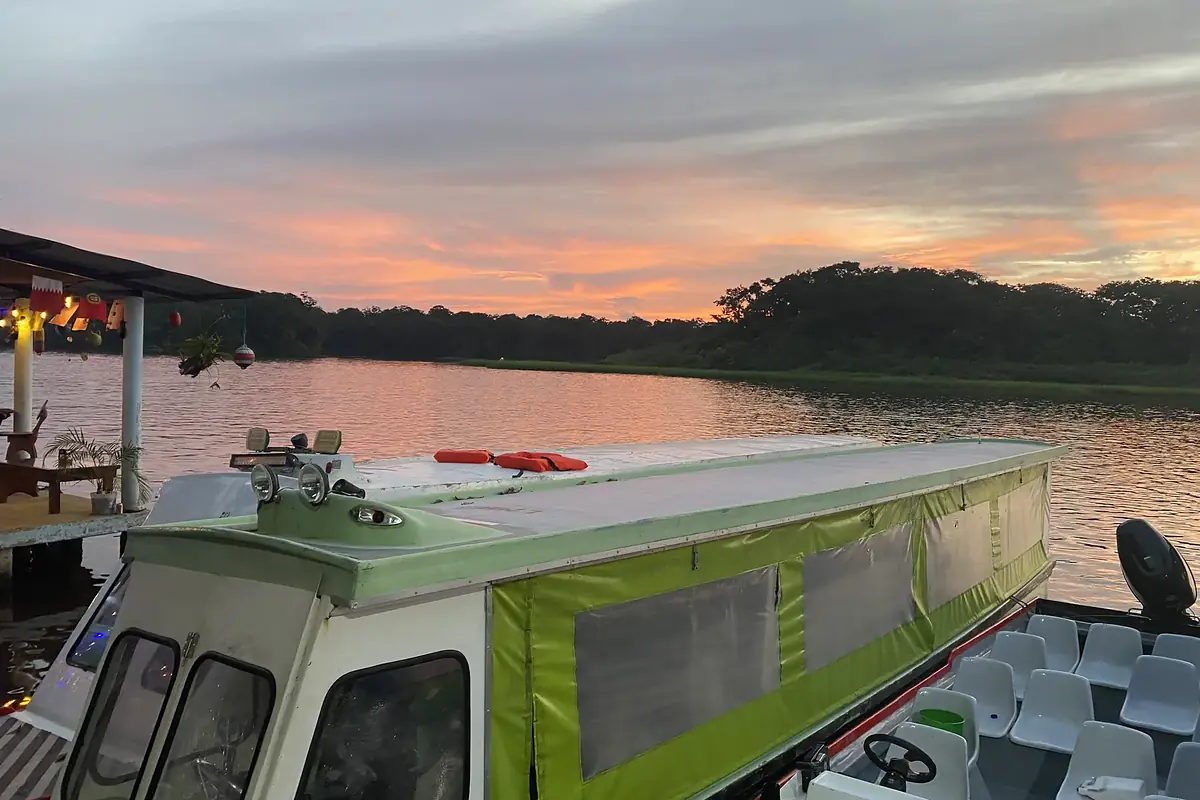 Ausflugsboot an einem Anleger bei Sonnenuntergang über dem Wasser
