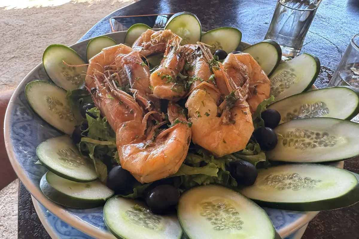 Gegrillte Garnelen auf Salat mit Gurkenscheiben und Oliven